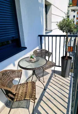 a patio with a table and chairs on a balcony at Beril lux apartman in Jagodina