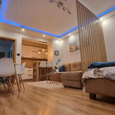 a living room with a couch and a dining room at Lux Apartman Kop Zoned in Kopaonik