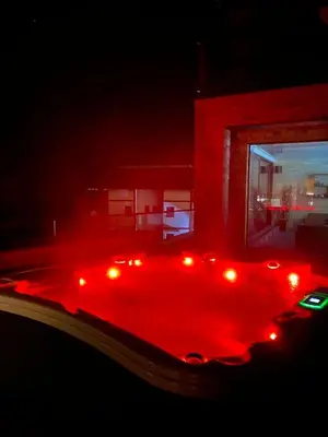 a bed with red lights in a dark room at Lux Apartman Kop Zoned in Kopaonik