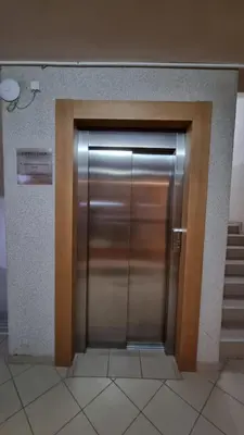 a metal elevator door in a building with stairs at Lux Apartman Kop Zoned in Kopaonik