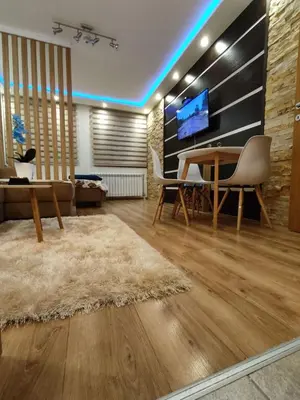 a living room with a table and a tv at Lux Apartman Kop Zoned in Kopaonik