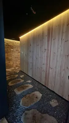 a room with a wooden wall and a row of stepping stones at Lux Apartman Kop Zoned in Kopaonik