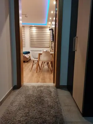 a door leading into a room with a table and chair at Lux Apartman Kop Zoned in Kopaonik