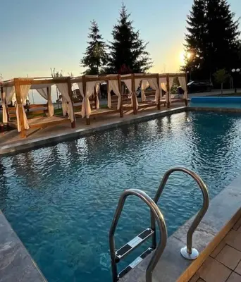 a swimming pool with a hand rail in the water at Residence Hill Kopaonik in Kopaonik