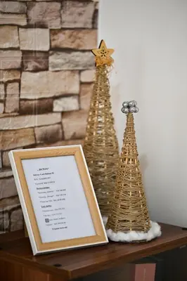 a table with two christmas trees and a picture at Apartman Dunja in Kraljevo