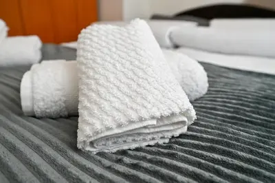 a pile of towels sitting on a bed at Apartman Dunja in Kraljevo