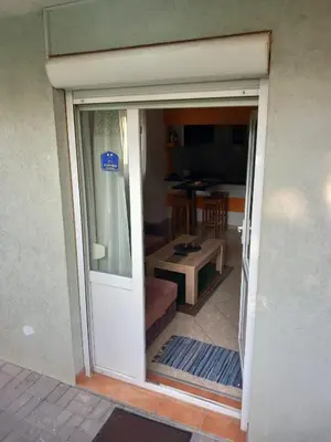 an open door to a living room with a table at Apartman Ilić in Vrnjačka Banja