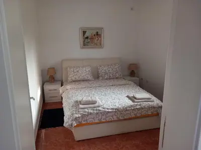 a small bedroom with a bed and a picture on the wall at Apartman Ilić in Vrnjačka Banja