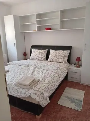a bedroom with a bed with white sheets and pillows at Apartman Ilić in Vrnjačka Banja