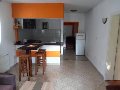 a kitchen with a table and chairs and a refrigerator at Apartman Ilić in Vrnjačka Banja