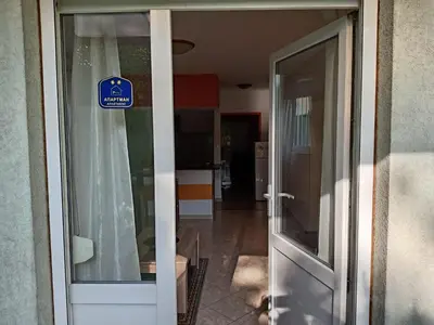 a sliding glass door with a sign in a hallway at Apartman Ilić in Vrnjačka Banja