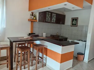 a kitchen with a black counter top and wooden stools at Apartman Ilić in Vrnjačka Banja