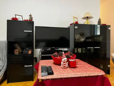 a room with a table with a remote control and a television at Asami in Vrnjačka Banja