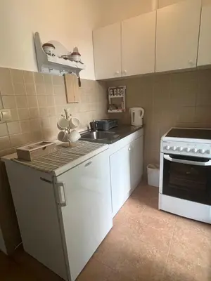 a kitchen with white cabinets and a sink and a stove at Asami in Vrnjačka Banja