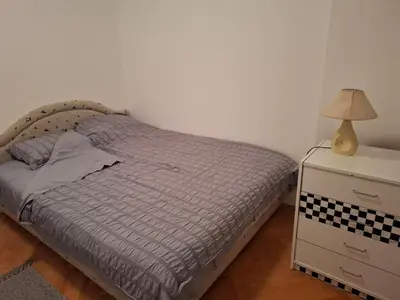 a bedroom with a bed and a nightstand with a lamp at Asami in Vrnjačka Banja