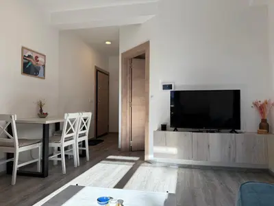 a living room with a television and a table and chairs at Vila Elena in Kopaonik