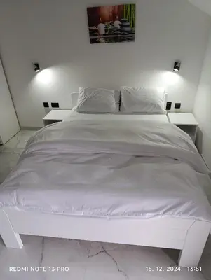 a white bed with white sheets and pillows at Garfield Family Studio 1 in Soko Banja