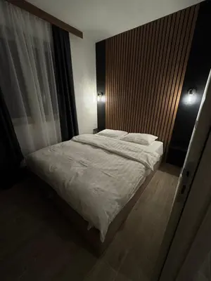a bedroom with a bed with a wooden headboard at Friends Lux apartment Kopaonik in Kopaonik
