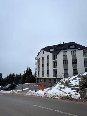 a large white building on the side of a road at Friends Lux apartment Kopaonik in Kopaonik