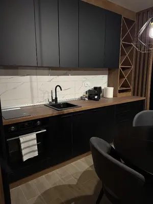 a kitchen with black cabinets and a sink at Friends Lux apartment Kopaonik in Kopaonik