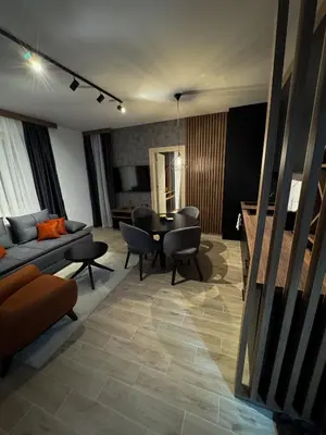 a living room with a couch and a table and chairs at Friends Lux apartment Kopaonik in Kopaonik