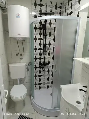 a bathroom with a shower with a toilet and a sink at Garfield Family Studio 2 in Soko Banja