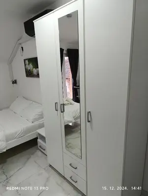a white cabinet with a mirror in a bedroom at Garfield Family Studio 2 in Soko Banja