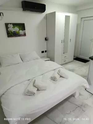 a bedroom with a white bed with towels on it at Garfield Family Studio 2 in Soko Banja