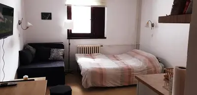 a bedroom with a bed and a chair and a window at Vila Yeti Kopaonik in Kopaonik