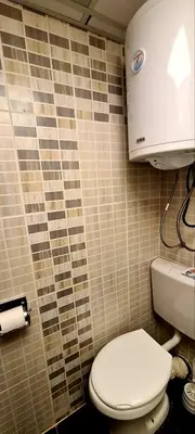 a bathroom with a toilet and a roll of toilet paper at Vila Yeti Kopaonik in Kopaonik