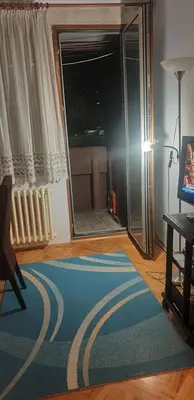 a living room with a blue rug and a mirror at Smart 2 in Niš