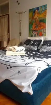 a bedroom with a bed with a painting on the wall at Smart 2 in Niš