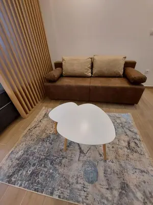 a living room with a couch and a white coffee table at Apartman Čarolija, Sunčana planina in Kopaonik