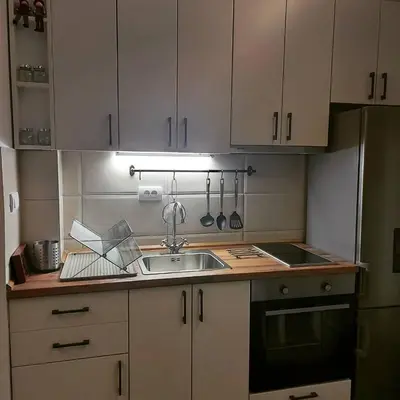 a kitchen with white cabinets and a sink at Apartman Čarolija, Sunčana planina in Kopaonik