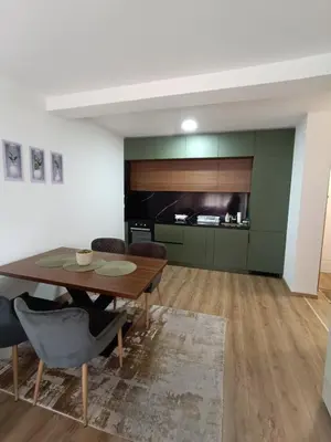 a dining room with a wooden table and chairs at Luksuzni Apartman Ema 2 in Pirot