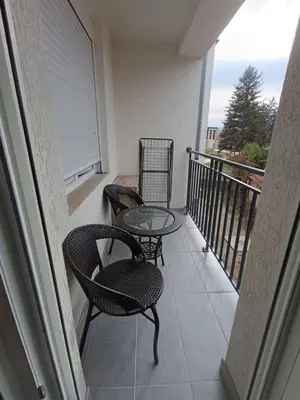 a balcony with two chairs and a glass table at Luksuzni Apartman Ema 2 in Pirot