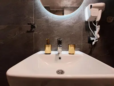 a bathroom sink with two candles and a phone at HILL Lux Apartman 1, FREE Secure private yard PARKING 2 place, DESIGNER home & WI-FI rooms & SMART TVx3 & 2 Bedroom & Rooms & Apartments Nis in Niš