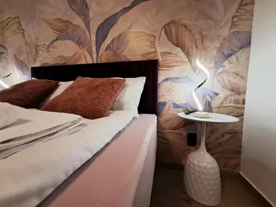 a bedroom with a bed with a flower patterned wall at HILL Lux Apartman 1, FREE Secure private yard PARKING 2 place, DESIGNER home & WI-FI rooms & SMART TVx3 & 2 Bedroom & Rooms & Apartments Nis in Niš
