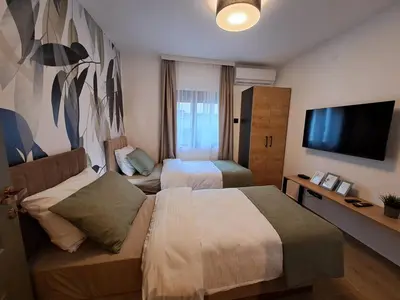 a hotel room with two beds and a flat screen tv at HILL Lux Apartman 1, FREE Secure private yard PARKING 2 place, DESIGNER home & WI-FI rooms & SMART TVx3 & 2 Bedroom & Rooms & Apartments Nis in Niš