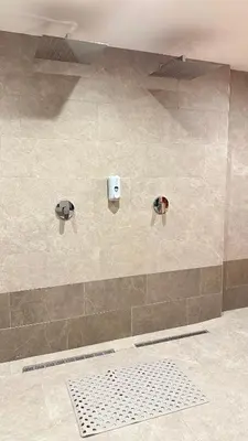 a shower in a bathroom with two lights on the wall at NORD VISTA Premium Alpine and SPA Experience in Kopaonik