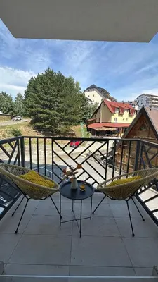 a patio with two chairs and a table on a balcony at NORD VISTA Premium Alpine and SPA Experience in Kopaonik