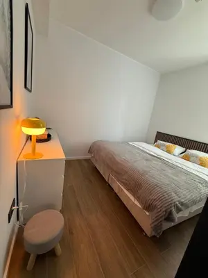 a bedroom with a bed and a table and a stool at NORD VISTA Premium Alpine and SPA Experience in Kopaonik