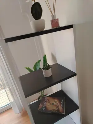 a shelf with a book and plants on it at Apartman Nataly 2 in Kruševac