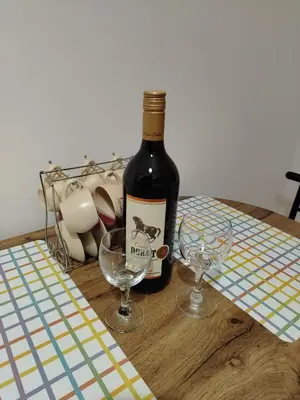 a bottle of wine and two glasses on a table at Apartman Nataly 2 in Kruševac