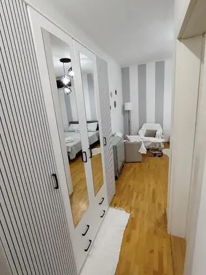 a white room with a hallway with a mirror at Apartman Nataly 2 in Kruševac