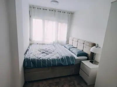a bed in a bedroom with a window at Apartman Sale lux in Leskovac