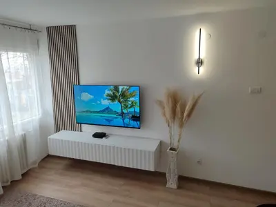 a living room with a flat screen tv on a wall at Apartman Sale lux in Leskovac