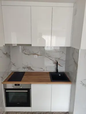 a kitchen with white cabinets and a sink at Apartman Sale lux in Leskovac