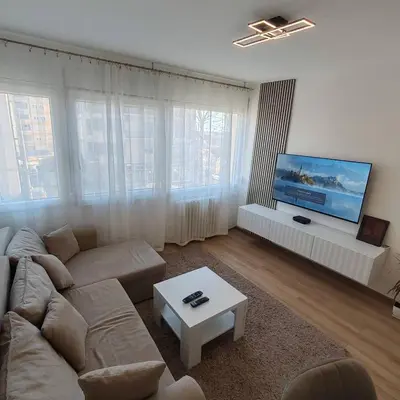 a living room with a couch and a flat screen tv at Apartman Sale lux in Leskovac