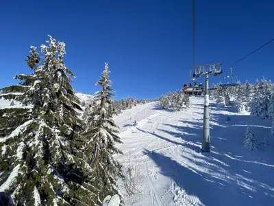 a ski lift with snow covered trees on a ski slope at Konaci Koznik Porodični in Kopaonik